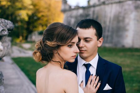 Happy Bride and groom at wedding Day walking Outdoors on castle territory. Bridal couple, Newlywed woman and man embracing with loveの写真素材