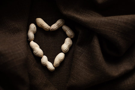 Heart shaped peanuts on brown cloth