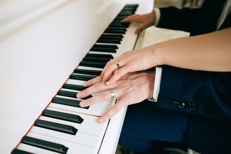 The bride and groom play the piano. Wedding traditionsの写真素材