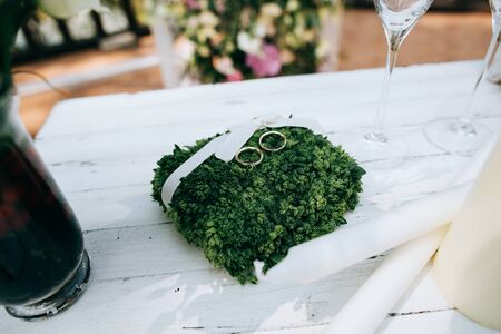 Golden wedding rings on green moss, rustic style. Wedding decor and accessoriesの写真素材