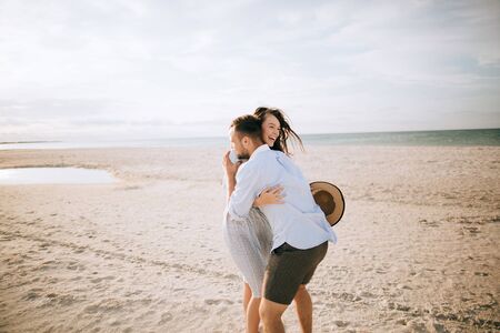 Young couple walking on the beach and hugging. Summer vacation at the seaの写真素材