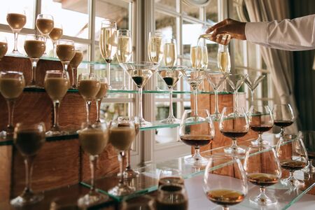 Catering service. Wedding drink bar. Waiter pouring champagne into a glass	の写真素材