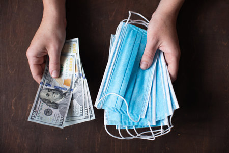 Woman holding dollars banknotes money and medical protective masks. Social and economic problems...