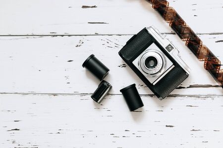 Retro camera, old photo film rolls on white wooden background. top view, text spaceの写真素材