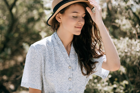 Summer portrait of a young happy woman in hat