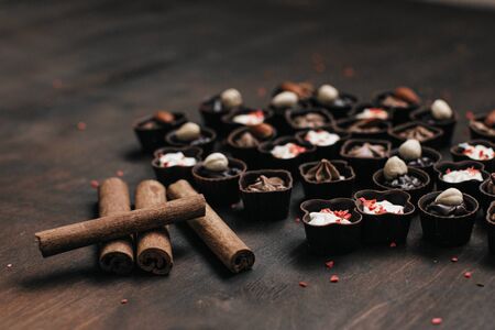 chocolate candy and cinnamon on a brown wooden background. sweets. text spaseの写真素材