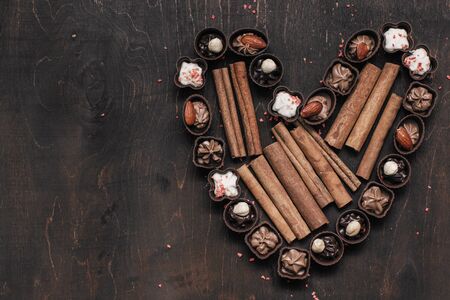 heart with chocolate candy and cinnamon on vintage wooden background. Love concept. Women day	の写真素材