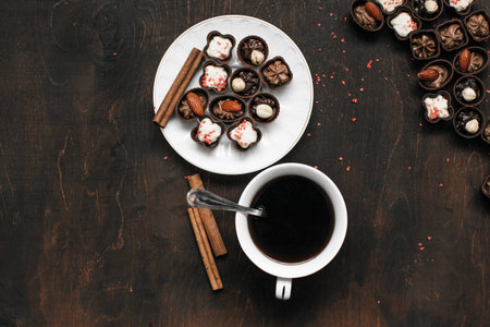 cup of coffee and chocolate candy on wooden table. Morning breakfast. Work, relax concept	
