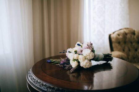 White wedding bouquet of peonies on a wooden table. Wedding accessoriesの写真素材