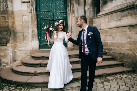 bride and groom celebrating their marriage on the old city in Europe. wedding concept	の写真素材