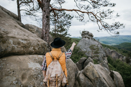 A man in a hat points to the mountain. Travel concept