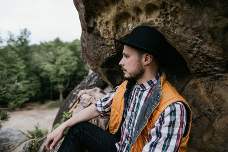 Portrait of a young bearded man in a hat outdoors