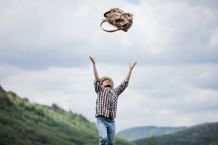 Young male tourist throws his backpack upの写真素材