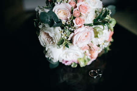 Wedding bouquet of white and pink flowers and wedding ringsの写真素材