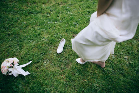 Wedding bouquet of white and pink roses lies on the green grass. Wedding accessoriesの写真素材