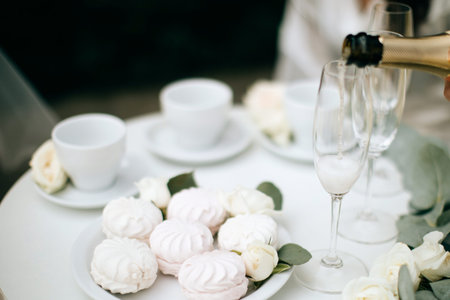White and pink marshmallows and champagne on the wedding table. Festive dinner