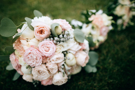 Beautiful wedding bouquet of pink and white roses and eucalyptus leaves on green grass. Wedding accessories
