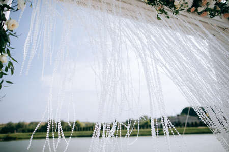 Wedding set up, outdoor wedding reception with arch on the shore of the lakeの写真素材