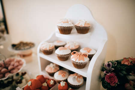 Red donuts and cakes in white wooden boxes on a dessert table. Candy barの写真素材