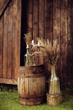 Wedding decorations with dry grass, wooden barrel and candles in boho styleの写真素材