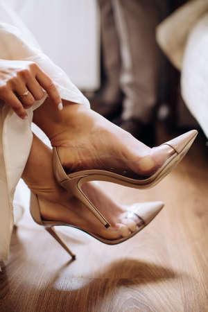 The bride wears shoes at the hotel. Wedding morning of the brideの写真素材