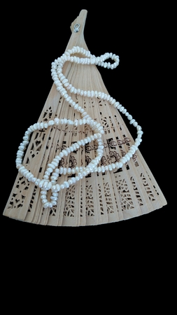 Pearls on the wooden fan on blackの写真素材