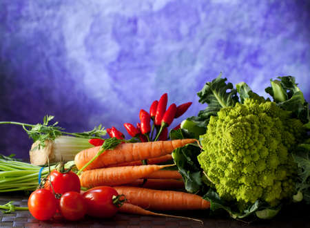Vegetables such as tomatoes, cabbages, carrots and peppers on a purple background の写真素材