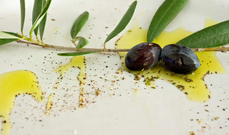Black olives, spices and oil on a dishの写真素材