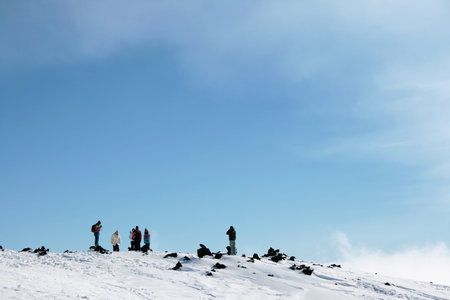 People walking on Etna Volcano covered by snow 