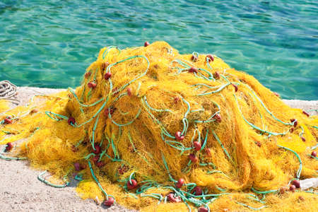 Yellow fishing nets next to the seaの写真素材