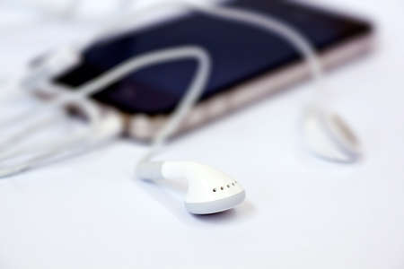 Smart phone and headphones isolated on a white backgroundの写真素材