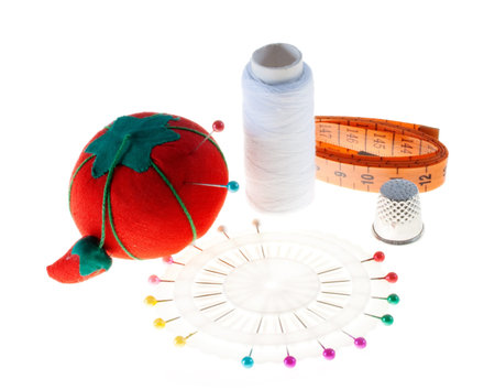 Pincushion, needle, cotton thread and tape