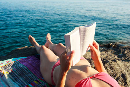 Girl Reading book in the beach, Pantelleriaの写真素材