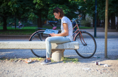 MILAN, ITALY - MAY, 17: Woman reading a magazine next to the bike on May 17, 2014のeditorial素材