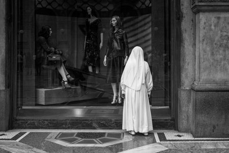 MILAN, ITALY - SEPTEMBER, 20: Nun looking the window shop in Milan on September 20, 2014のeditorial素材