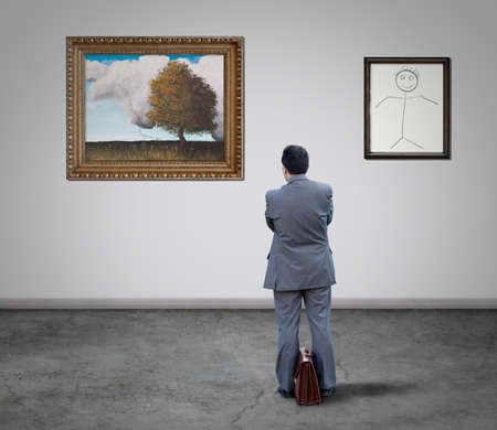 Businessman looking at the art gallery paintingsの写真素材