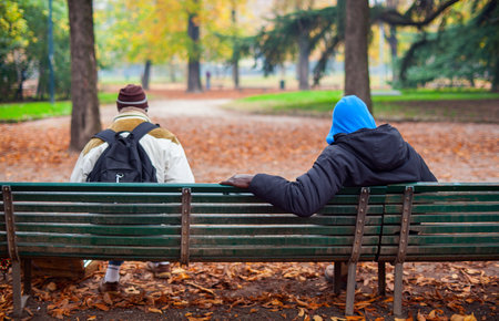 MILAN, ITALY - NOVEMBER, 24: View of two people sitting on the bench on November 24, 2014のeditorial素材