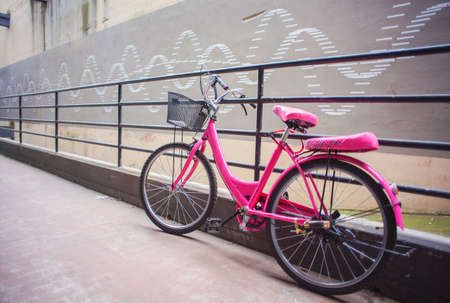 View of pink bicycle next to the iron railingの写真素材