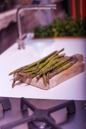 View of bunch of fresh asparagus on cutting boardの写真素材
