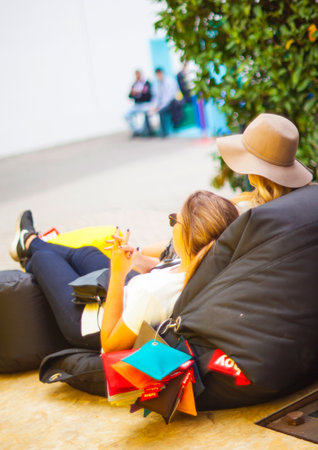 MILAN ITALY APRIL 16: Two young girls lie down on pouf space location at Tortona during Milan Design Week on April 16 2015のeditorial素材