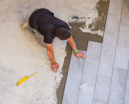 TRIESTE, ITALY - APRIL, 22: Worker Installing ceramic floor tiles on April 22, 2015のeditorial素材