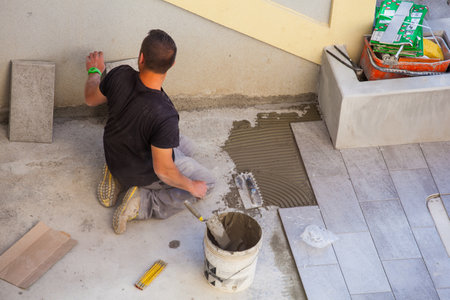 TRIESTE, ITALY - APRIL, 22: Worker Installing ceramic floor tiles on April 22, 2015のeditorial素材