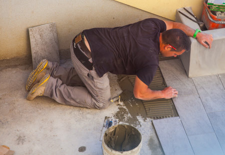 TRIESTE, ITALY - APRIL, 22: Worker Installing ceramic floor tiles on April 22, 2015のeditorial素材