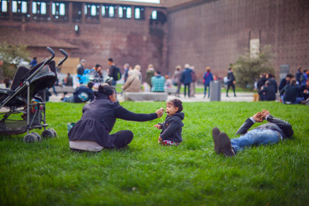 MILAN, ITALY - MARCH, 29: Mother in the park feeding her baby girl with a spoon on March 29, 2015のeditorial素材