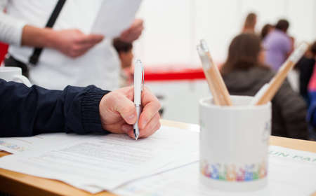 Close up on caucasian hand fill a formの写真素材