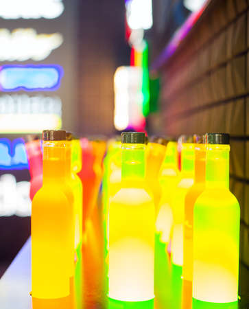 View of yellow illuminated bottles on the tableの写真素材
