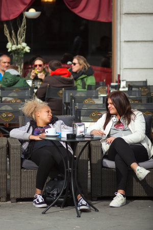 TRIESTE, ITALY - APRIL, 28: Girlfriens talking sitting in the outdoor coffee bar on April 28, 2016のeditorial素材