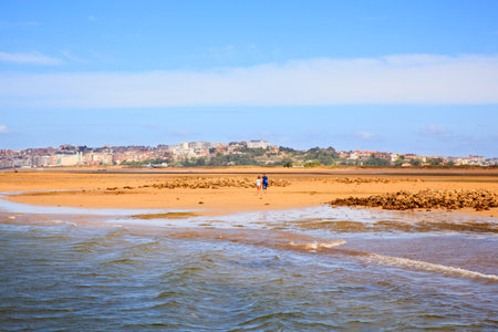 SANTANDER, SPAIN - AUGUST, 20: Couple walking on the El Puntal beach in Somo on August 20, 2016のeditorial素材