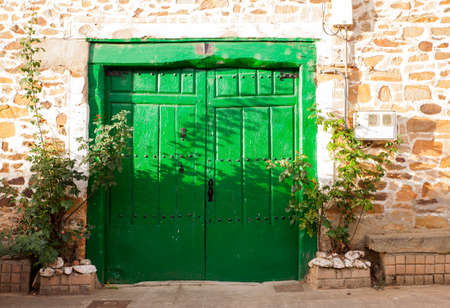 Old green door of a poor Spanish houseの写真素材