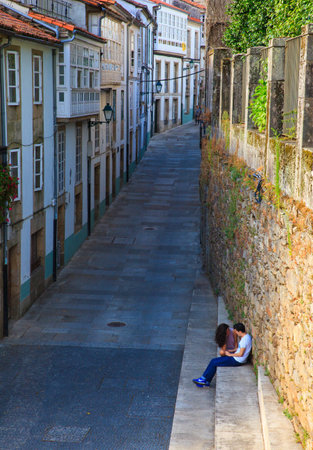 SANTIAGO, SPAIN - AUGUST, 17: Couple of teen lovers sitting on staircase on August 17 2016のeditorial素材